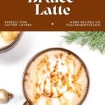 Overhead view of a caramel brûlée latte in a mug, topped with caramel drizzle and crushed candy.