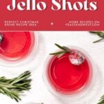 Three red jello shots garnished with cranberries and rosemary on a white background, holiday-themed text above.