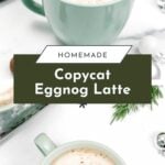 Two green mugs filled with frothy eggnog latte, garnished with spices, on a white surface with festive greens.