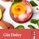 A pink cocktail with ice and an orange garnish, topped with mint. Text: Gin Daisy, perfect for spring & summer.