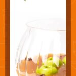 A glass bowl filled with orange punch, green apple slices, and star anise, labeled “Poison Apple Halloween Punch.”.