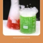 Two laboratory beakers filled with smoking red and green drinks for Halloween.