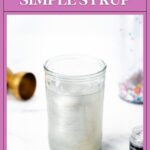 A jar of silver edible glitter simple syrup on a white surface.