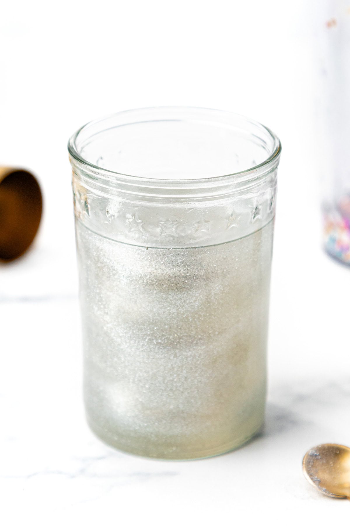 A clear glass jar filled with a shimmering, silvery liquid.